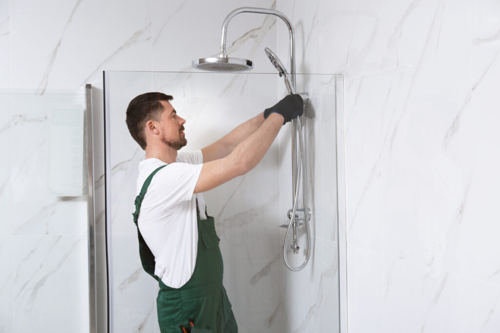Plumber working inside a residential shower