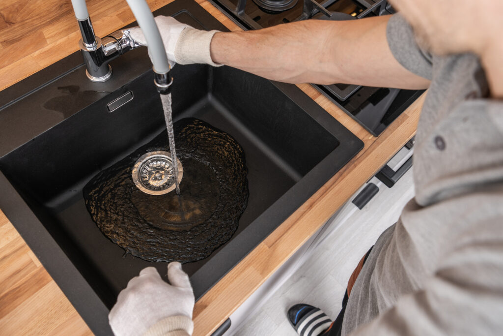 Plumber cleaning a kitchen sink drain