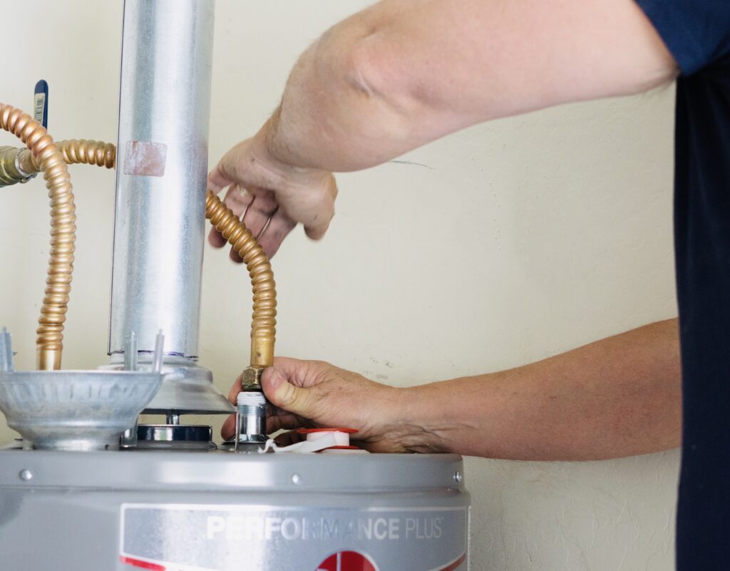Plumber connecting pipes to a water heater